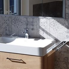 Ein modernes Badezimmer mit einem eleganten Waschbecken aus weißem Keramik und einem Holzschrank darunter.
